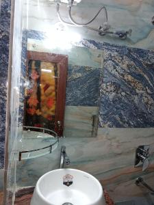 ein Badezimmer mit Waschbecken und Spiegel in der Unterkunft Hotel Dinantika International in Bolpur