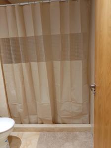 a shower curtain in a bathroom with a toilet at Les belles loges in Bouskoura