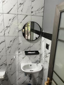 a bathroom with a white sink and a mirror at D nux House in Ngurah Rai International Airport