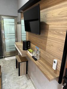 a flat screen tv on a wall in a hotel room at D nux House in Ngurah Rai International Airport
