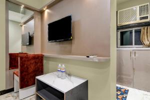 a living room with a television and two water bottles on a table at Hotel O KOLKATA SEVEN INN LLP in Salkhia +21 photos