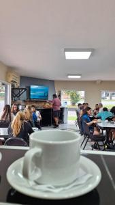Eine Kaffeetasse steht auf einem Tisch in einem Klassenzimmer. in der Unterkunft KIN Hotel in Villa Carlos Paz