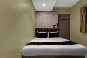 a bedroom with a large white bed with black pillows at Hotel O KOLKATA SEVEN INN LLP in Salkhia