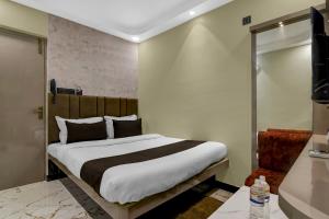 a bedroom with a bed and a chair at Hotel O KOLKATA SEVEN INN LLP in Salkhia