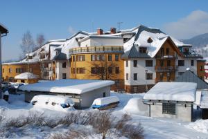 a group of buildings with snow covered roofs at Apartmán Rokytka 205 in Rokytnice nad Jizerou