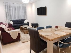 a living room with a table and a couch at Les belles loges in Bouskoura