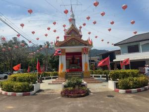 ein kleiner Tempel mit roten Fahnen und roten Fahnen in der Unterkunft Lanta natural hut garden in Phra Ae beach