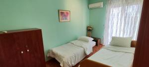 een kamer met twee bedden en een raam bij Luxurious Apartment Drama in Drama