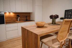 a kitchen with a wooden table with a bowl on it at Portside Residence Piräus in Piraeus +22 photos