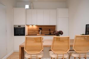 a kitchen with white cabinets and a table and chairs at Portside Residence Piräus in Piraeus