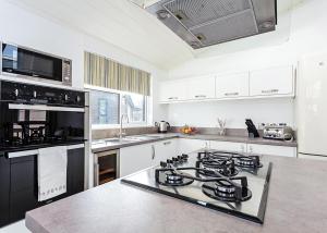 a kitchen with white cabinets and a stove top oven at Woodside Bay Lodge Retreat in Wootton Bridge