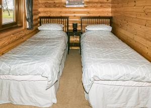 2 letti in una baita di tronchi con tavolo di Laxfield Lodges a Laxfield Altre 11 foto