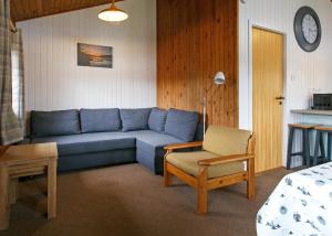 een woonkamer met een blauwe bank en een stoel bij Lochearnhead Loch Side in Lochearnhead