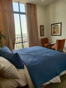 ein Schlafzimmer mit einem blauen Bett und einem Fenster in der Unterkunft Sky Park Nest in Islamabad