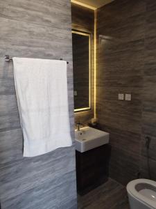 ein Bad mit einem Waschbecken und einem weißen Handtuch in der Unterkunft Sky Park Nest in Islamabad