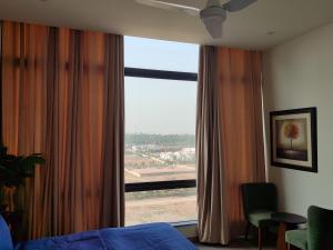 Schlafzimmer mit einem großen Fenster mit Aussicht in der Unterkunft Sky Park Nest in Islamabad