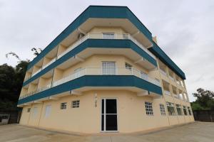 a tall building with a blue roof at Recanto Ubaduba in Ubatuba