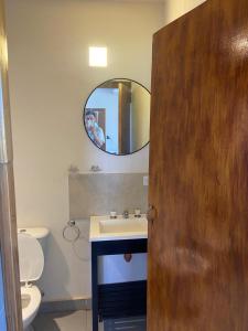 una persona che scatta una foto di un bagno con specchio di Loft serenity a Villa Carlos Paz
