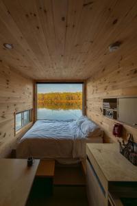 una camera da letto con un letto e una grande finestra di Postcard Cabins Talladega Valley, Outdoor Collection by Marriott Bonvoy a Childersburg
