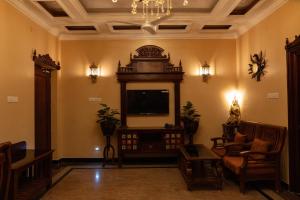 a living room with a tv and a couch and chairs at SK Grand Palace in Pondicherry
