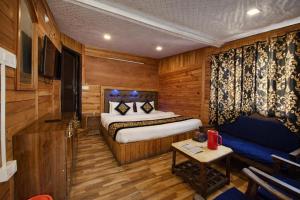 ein Schlafzimmer mit einem Bett und einer Couch in einem Zimmer in der Unterkunft Hotel Naini -Lake -View Near The Mall Road - Restaurant And Free Wifi All Rooms - Prime Location - Best Hotel in Nainital