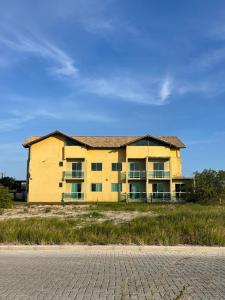 een groot geel gebouw aan de kant van een weg bij Pousada Reis in Imbituba