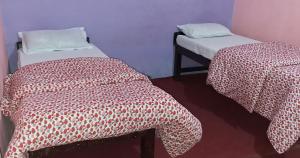two beds in a room with red and white sheets at Kimche Guest House in Astam +12 photos