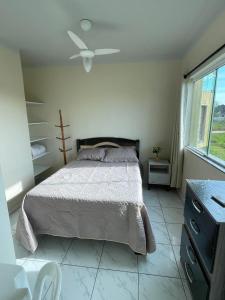 een slaapkamer met een bed en een plafondventilator bij Pousada Reis in Imbituba +38 foto's
