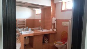 a bathroom with two sinks and a toilet at Apartament modern 3 camere ultracentral McDonalds Orange in Craiova +9 photos