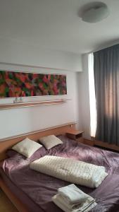 a bed with two pillows on it in a bedroom at Apartament modern 3 camere ultracentral McDonalds Orange in Craiova