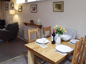 een eetkamer met een houten tafel met bloemen en wijnglazen bij The Chapel in Staveley