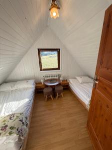 een kamer met 2 bedden en een tafel in een tent bij Spacerowy Zakątek in Ślemień