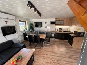 a kitchen and living room with a couch and a table at Spacerowy Zakątek in Ślemień