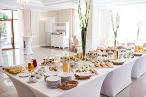 a long white table with food on it at Hotel Cztery Pory Roku in Bielsk Podlaski