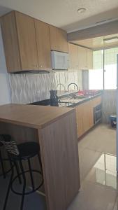 eine Küche mit Holzschränken und einer Arbeitsplatte in der Unterkunft Q 461 Apartamento 02 quartos mobiliado in São Borja