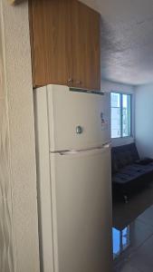 einen weißen Kühlschrank in einem Zimmer mit Sofa in der Unterkunft Q 461 Apartamento 02 quartos mobiliado in São Borja + 9 Fotos