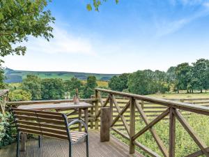 een houten terras met een tafel en een bank op een balkon bij Hygge Cabin in Hexham +24 foto's