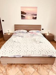 een groot bed in een slaapkamer met 2 nachtkastjes bij Casa Mary in Domodossola