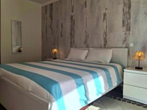 een slaapkamer met een groot bed met blauwe en witte lakens bij Refugio Madeira in Caniço