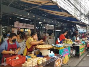 un gruppo di persone che preparano il cibo al mercato di 1BR Near BTS Queen & Single Bed City Center a Bangkok