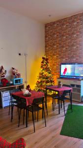 een woonkamer met een kerstboom en tafels en stoelen bij Hostel Dolce di Monica in Napels