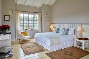 a bedroom with a bed and a chair and a window at Soames Hotel & Jack' s Bar in Nanyuki