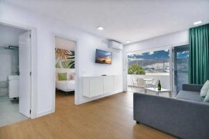 un soggiorno con un divano e una camera da letto di Palm Suites a Puerto Rico de Gran Canaria