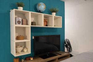 a living room with a tv and a blue wall at Le Retro Gaming - Le Havre Train Station in Le Havre