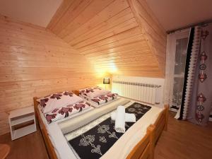 una camera da letto con un grande letto in una camera in legno di Willa Grzesiczek a Zakopane
