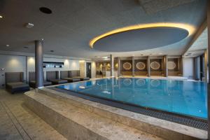 a large swimming pool in a hotel room at Chalet Tyrolian Apartments - by Familiaris - Pools 500 meters in Valdaora