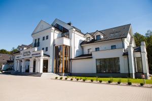 uma grande casa branca com uma entrada em Hotel Cztery Pory Roku em Bielsk Podlaski