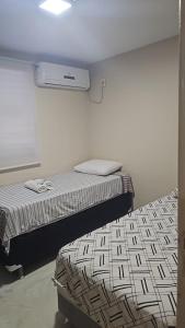 En eller flere senge i et værelse på O 353 Apartamento mobiliado completo 02 quartos com garagem