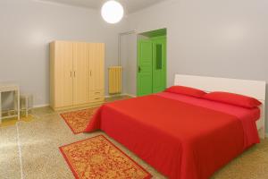 una camera con un letto rosso e una porta verde di Sole Rosso Acquario Rooms a Genova