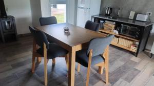 une table en bois avec quatre chaises dans une cuisine dans l'établissement Cabañas Don Ricardo, à Dolores